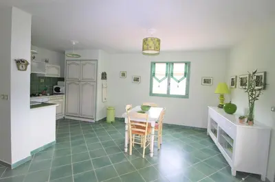 a kitchen and dining room with a table and chairs at Résidence U MELU Grand T2 VERT à l'étage in Tiuccia