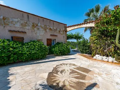 a house with a stone patio in front of a building at Holiday Home Campestra by Interhome in Coti-Chiavari
