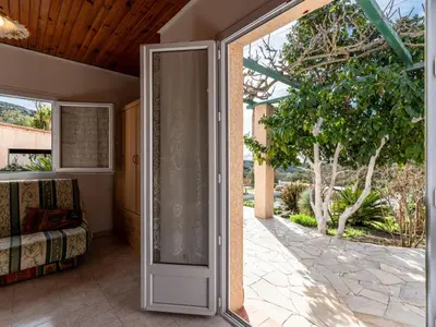 an open door to a patio with a bed at Holiday Home Campestra by Interhome in Coti-Chiavari