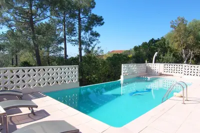 a swimming pool with two chairs and a fence at CELESTE in Capo