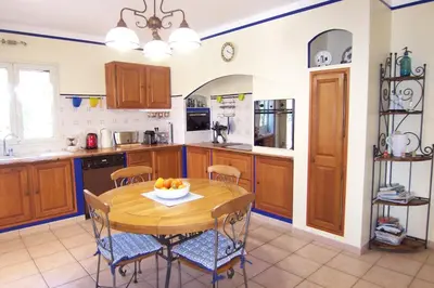 a kitchen with a wooden table and some chairs at CELESTE in Capo