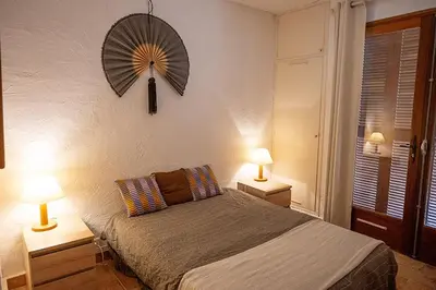 a bedroom with a bed with two lamps and a fan at Grande Villa, Corse du Sud, Domaine privé de Cala Rossa in Porto-Vecchio