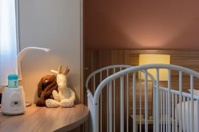 two stuffed animals sitting on a table next to a crib at Residence de Tourisme Ajaccio Amirauté in Ajaccio