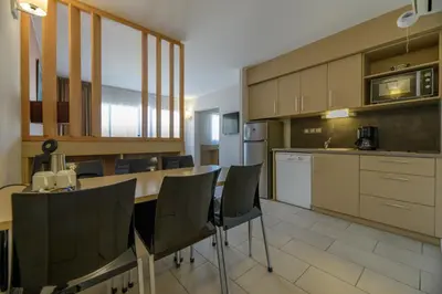 a kitchen with a table and chairs in a room at Residence de Tourisme Ajaccio Amirauté in Ajaccio