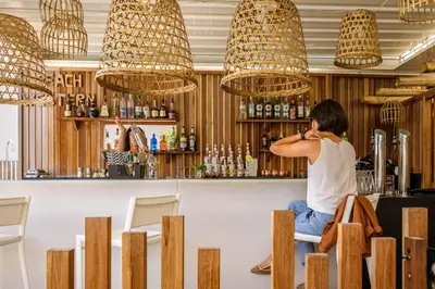 a woman sitting at a bar in a restaurant at Residence de Tourisme Ajaccio Amirauté in Ajaccio