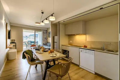 a kitchen and dining room with a table and chairs at Residence de Tourisme Ajaccio Amirauté in Ajaccio