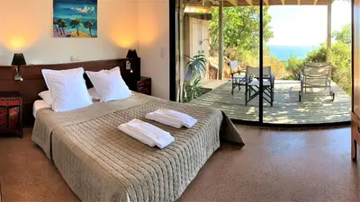 a bedroom with a bed with two towels on it at A ALTEZZA Palombaggia in Porto-Vecchio
