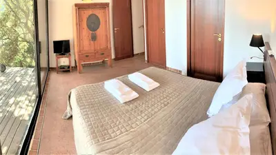 a bedroom with a bed with two towels on it at A ALTEZZA Palombaggia in Porto-Vecchio