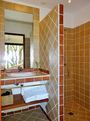 a bathroom with a sink and a mirror at A ALTEZZA Palombaggia in Porto-Vecchio
