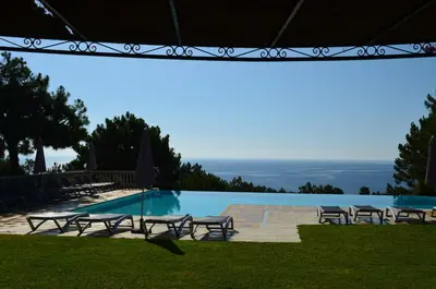 a pool with chairs and a view of the ocean at Residence Mare e Monte in Favone