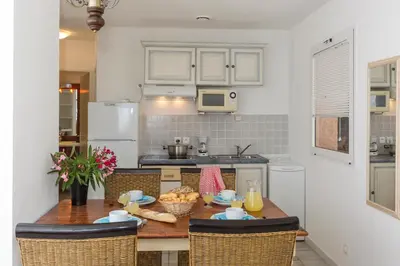 a dining room table with chairs and a television at Residence Mare e Monte in Favone