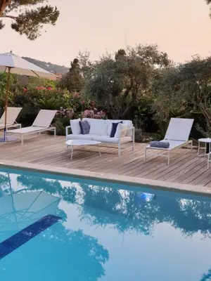 a pool with two lounge chairs and a table and an umbrella at Les Suites d'Agosta in Porticcio