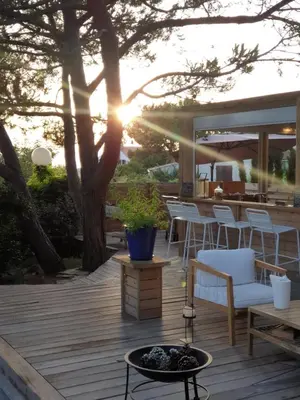 a deck with chairs and a table and a tree at Les Suites d'Agosta in Porticcio