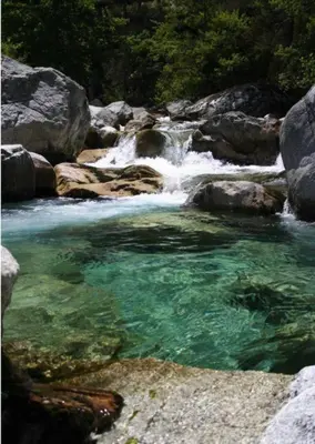 a stream of water in a river with rocks at Corté Centre Corse in Corte