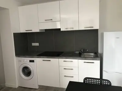 a kitchen with white cabinets and a washing machine at Corté Centre Corse in Corte