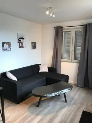 a living room with a black couch and a table at Corté Centre Corse in Corte