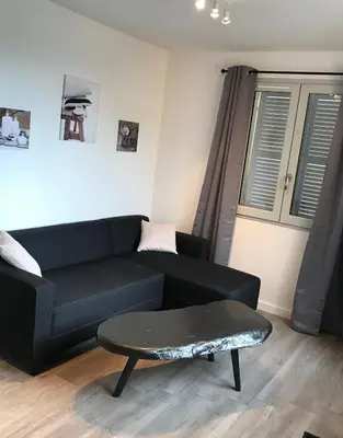 a living room with a black couch and a table at Corté Centre Corse in Corte