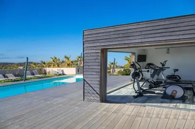 a house with a gym next to a swimming pool at Résidence Pierre & Vacances Premium Les Terrasses d'Arsella in Porto-Vecchio