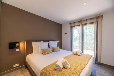 a bedroom with a large bed with towels on it at Résidence Pierre & Vacances Premium Les Terrasses d'Arsella in Porto-Vecchio