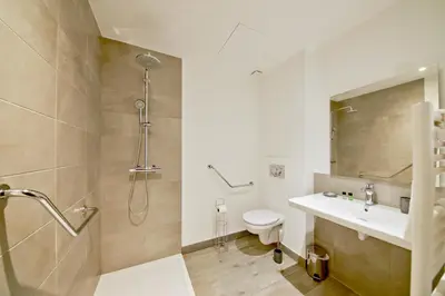 a bathroom with a shower and a toilet and a sink at Résidence Pierre & Vacances Premium Les Terrasses d'Arsella in Porto-Vecchio