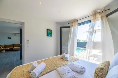 a bedroom with a bed with towels on it at Résidence Pierre & Vacances Premium Les Terrasses d'Arsella in Porto-Vecchio