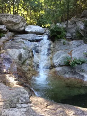 a waterfall on the side of a rocky hill at Bottega in Petreto-Bicchisano