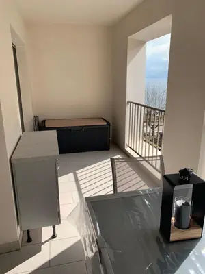 a room with a bed and a balcony at Studio les pieds dans l'eau Plage du Trottel in Ajaccio