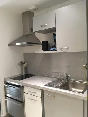 a kitchen with white cabinets and a sink at Studio les pieds dans l'eau Plage du Trottel in Ajaccio