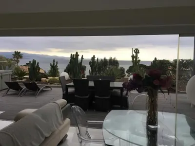 a glass table with a vase of flowers on a patio at Barbicaja in Ajaccio