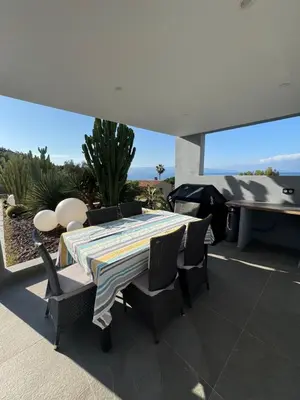 a table and chairs on a patio with a view of the ocean at Barbicaja in Ajaccio