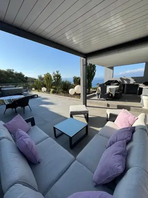 a couch on a patio with pillows and a table at Barbicaja in Ajaccio