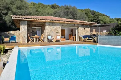 a villa with a swimming pool in front of a house at Domaine Valle Doniche in Olmeto