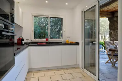 a kitchen with white cabinets and a window at Domaine Valle Doniche in Olmeto