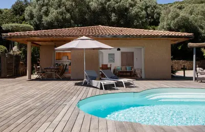 a patio with an umbrella and a swimming pool at Domaine Valle Doniche in Olmeto