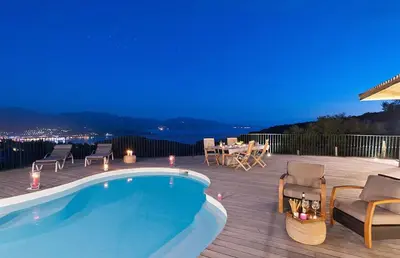 a swimming pool on a deck with a table and chairs at Domaine Valle Doniche in Olmeto