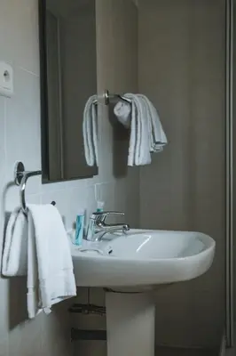 a bathroom with a sink and a mirror and towels at Résidence Idéal-Subrini in Porto Ota