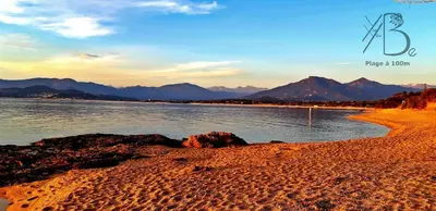 a view of a beach with mountains in the background at residence de porticcio, youyoube in Porticcio