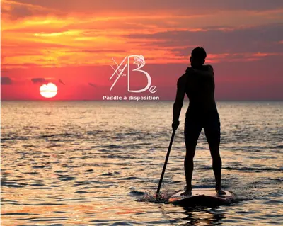 a man is standing on a paddle board in the water at residence de porticcio, youyoube in Porticcio