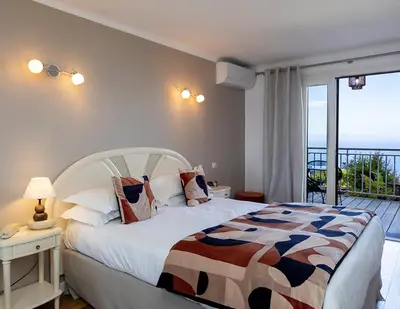 a bedroom with a bed with a view of the ocean at Hôtel Capo Rosso in Piana
