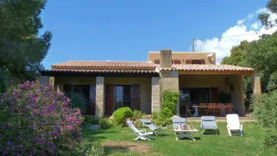 a house with chairs and a table in the yard at La Baraka in Pianottoli-Caldarello
