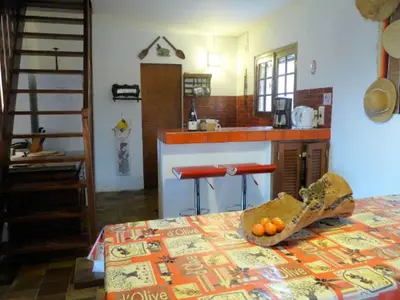 a kitchen with a table with a bowl of oranges on it at La Baraka in Pianottoli-Caldarello