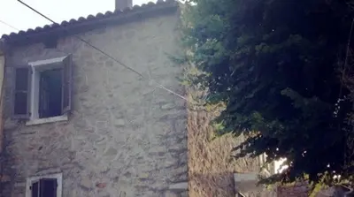 a brick building with a window and a tree at Maison de Vacances Renno in Renno