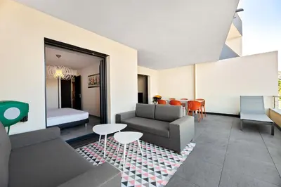 a living room with a couch and a table and chairs at Domaine du Frassu, T2 standing, plage à pied in Porticcio