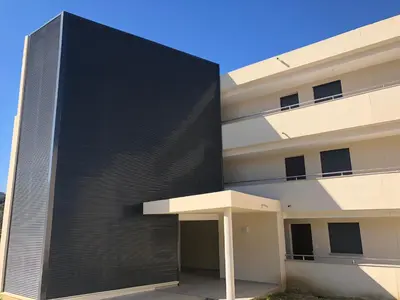 a building with a black wall at Domaine du Frassu, T2 standing, plage à pied in Porticcio