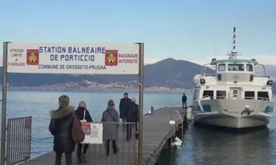 a group of people standing on a dock with a boat at Domaine du Frassu, T2 standing, plage à pied in Porticcio
