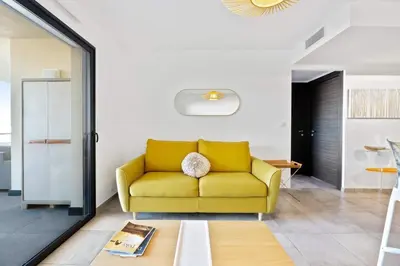 a yellow couch in a living room at Domaine du Frassu, T2 standing, plage à pied in Porticcio