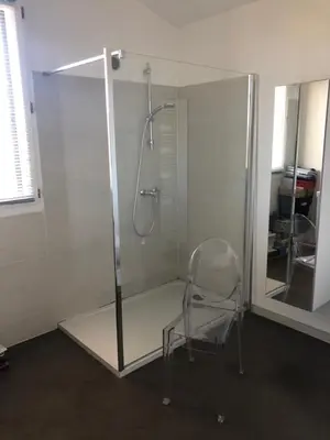 a glass shower with a chair in a room at Oliera 2 in Oletta