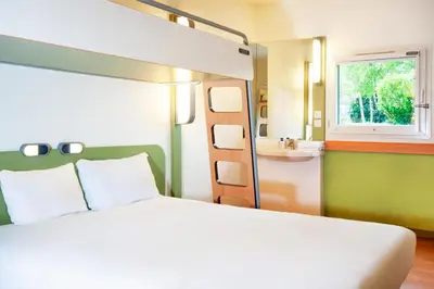 a bedroom with a bed and a sink and a bunk bed at ibis budget Ajaccio in Ajaccio