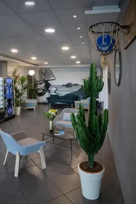 a cactus in a lobby with chairs and a couch at ibis budget Ajaccio in Ajaccio