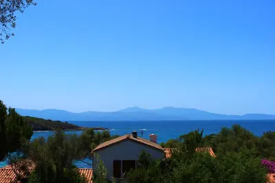 a house with the ocean in the background at Résidence Les Mandiles in Cargèse
